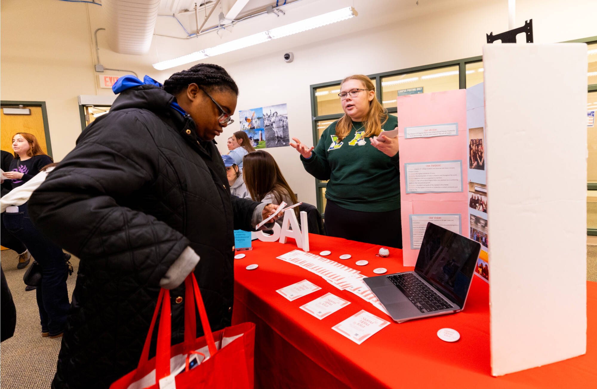 student sharing information about their organization by talking and using a flyer